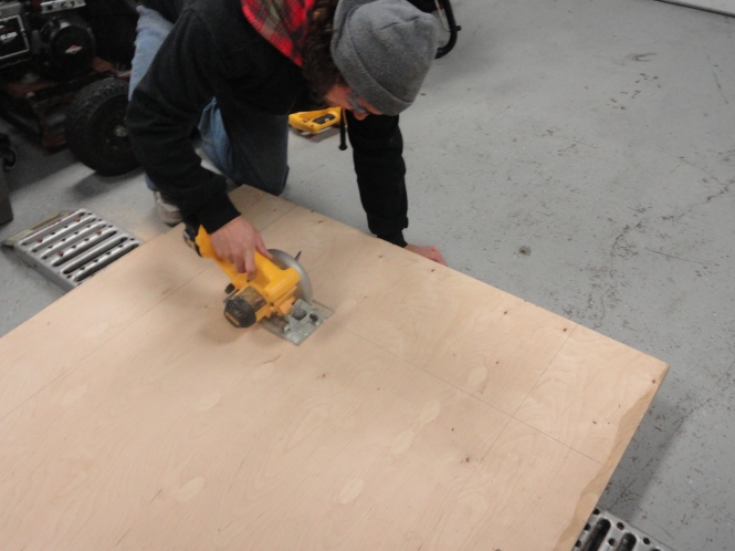 measuring and cutting plywood for DIY sliding barn door laminate wood flooring