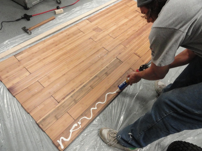 gluing liquid nails laminate wood flooring to plywood for DIY sliding barn door